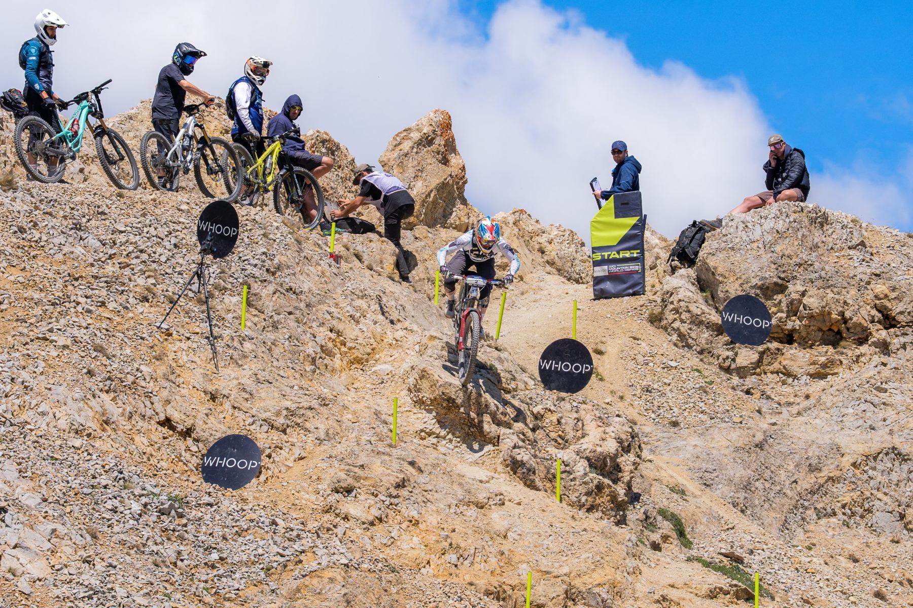 Harper dropping off the start of a rocky race stage while riders wait above
